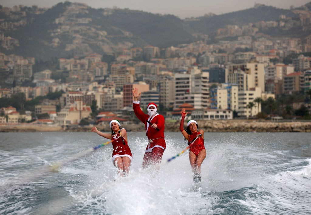 Участники ливанского клуба водных лыж выступают одетые в костюмы Санта Клауса в бухте Джуни, Ливан.